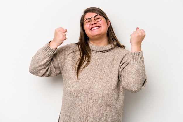 Joven mujer caucásica con sobrepeso aislada de fondo blanco celebrando una victoria, pasión y entusiasmo, expresión feliz