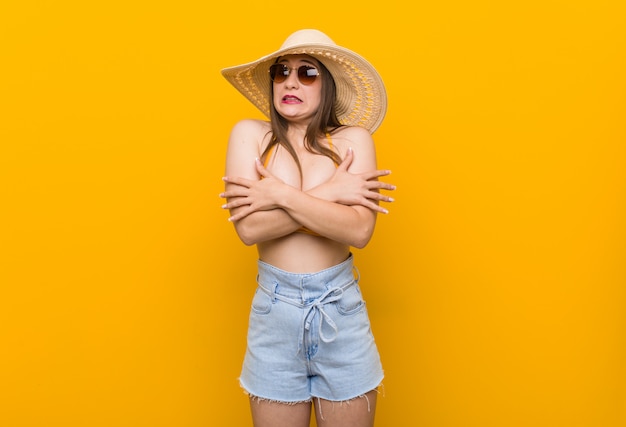 Joven mujer caucásica con un sombrero de paja, mirada de verano se enfría