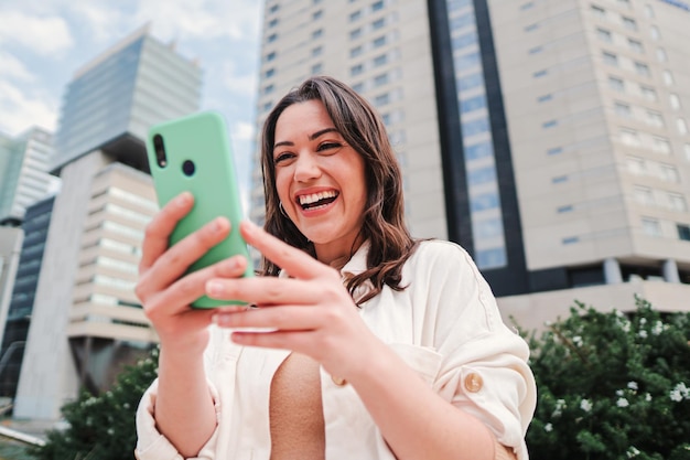 Joven mujer caucásica sonriendo buscando venta en Internet usando la aplicación de compras en línea Una mujer morena feliz emocionada usando el teléfono celular