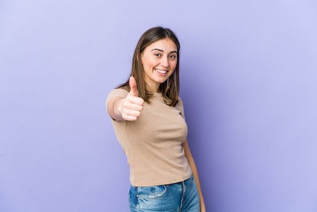 Joven mujer caucásica sonriendo y levantando el pulgar