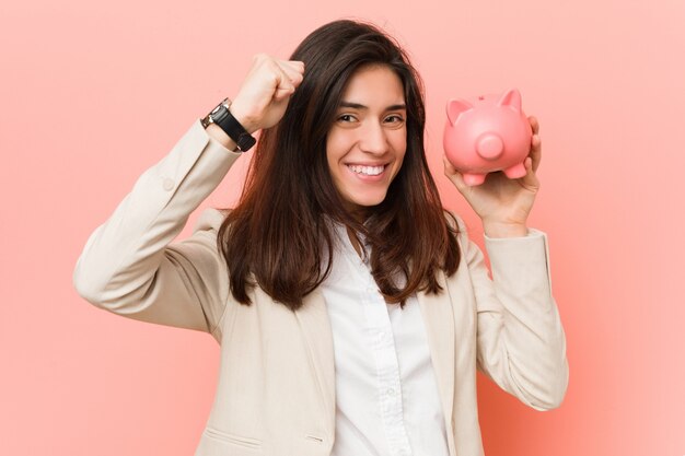 Joven mujer caucásica sosteniendo una alcancía