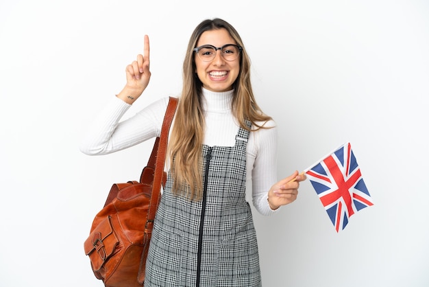 Joven mujer caucásica sosteniendo una bandera del Reino Unido aislada sobre fondo blanco apuntando hacia una gran idea