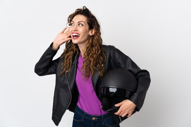 Joven mujer caucásica sosteniendo un casco de moto