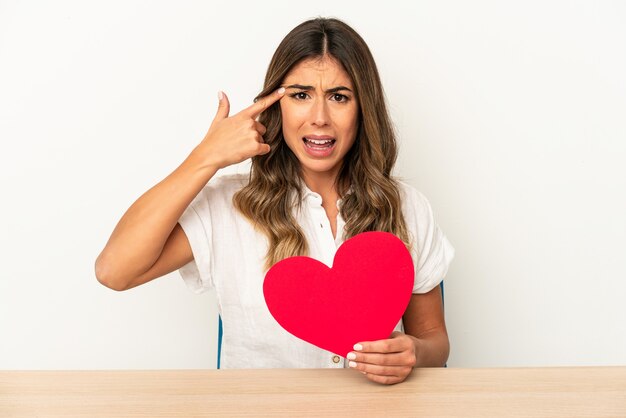 Joven mujer caucásica sosteniendo un corazón de San Valentín