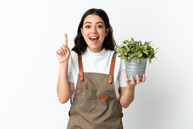 Joven mujer caucásica sosteniendo una planta aislada