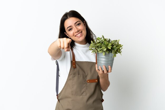 Joven mujer caucásica sosteniendo una planta aislada