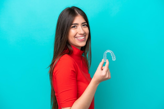 Foto joven mujer caucásica sosteniendo una previsión aislada de fondo azul sonriendo mucho