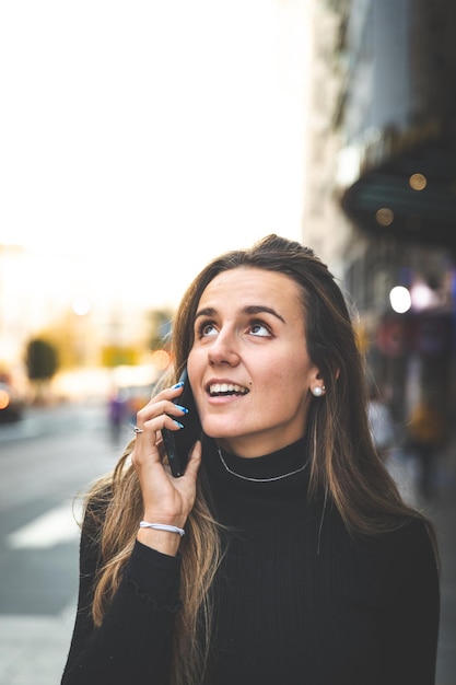 Joven mujer caucásica con un teléfono inteligente en la Gran Vía de Madrid, España.