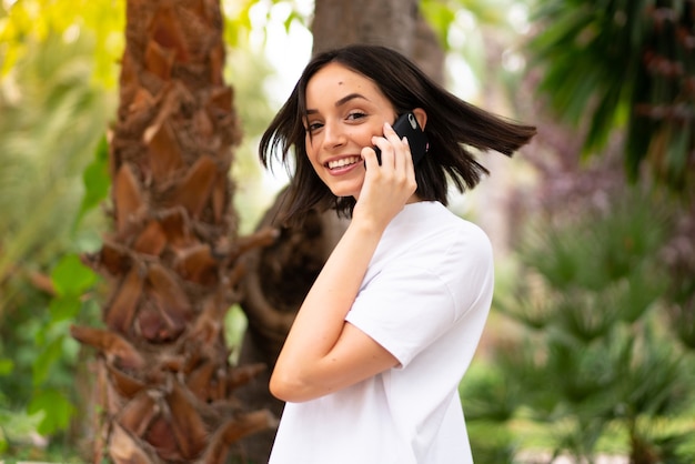 Joven mujer caucásica usando un teléfono al aire libre