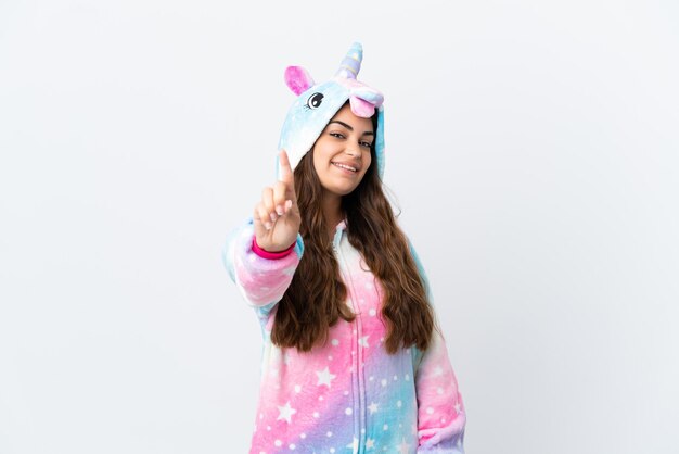 Joven mujer caucásica vistiendo un pijama de unicornio aislado sobre fondo blanco mostrando y levantando un dedo