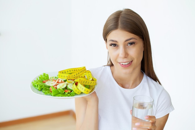 Joven mujer comiendo ensalada saludable después del ejercicio