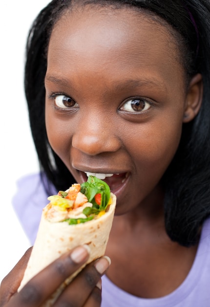 Joven mujer comiendo una envoltura