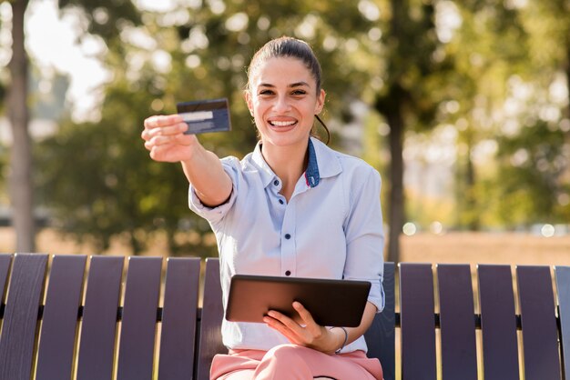 Foto joven mujer de compras en línea en el parque