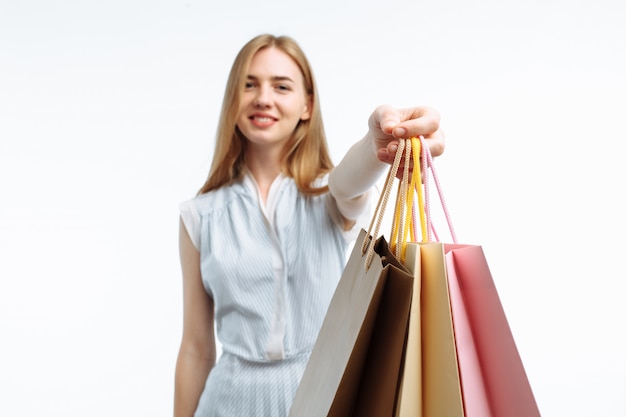 Joven mujer de compras, posando con bolsas de regalo