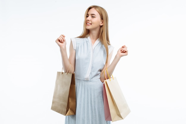 Joven mujer de compras, posando con bolsas de regalo