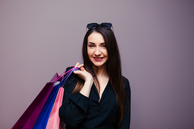 Joven mujer de compras de verano feliz con bolsas de compras aisladas en superficie