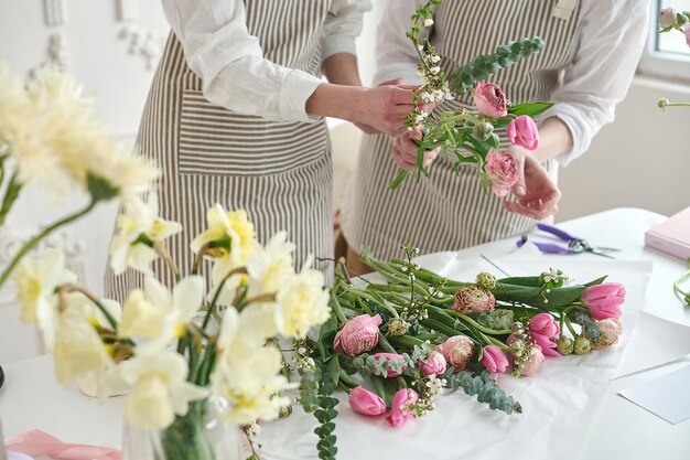 Joven mujer creativa en una floristería usando una computadora portátil