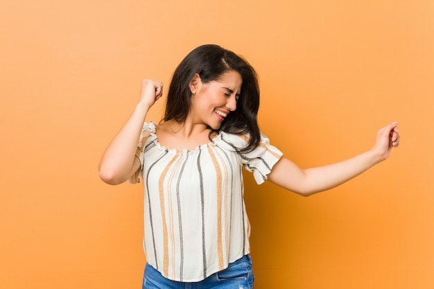 Joven mujer con curvas bailando y divirtiéndose.