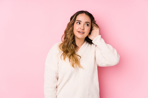 Joven mujer con curvas posando en rosa