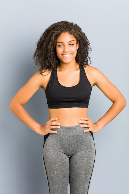 Joven mujer deportiva afroamericana posando