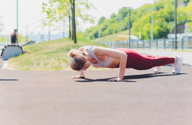 joven mujer deportiva haciendo ejercicio de estiramiento paseo marítimo