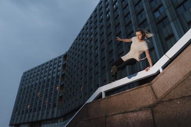 Joven mujer deportiva haciendo parkour en la ciudad