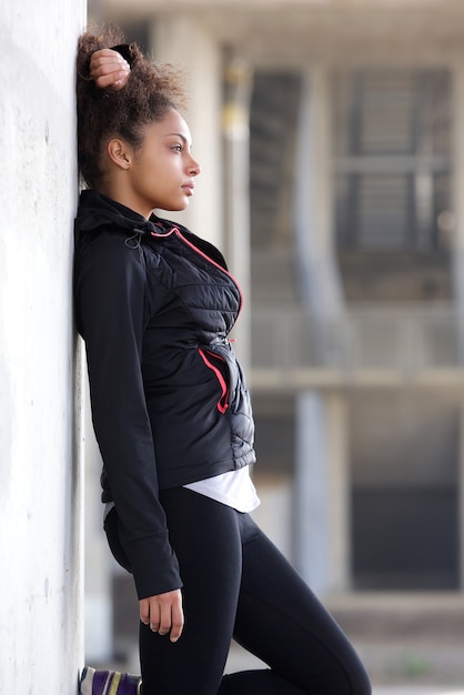 Joven mujer deportiva relajante al aire libre