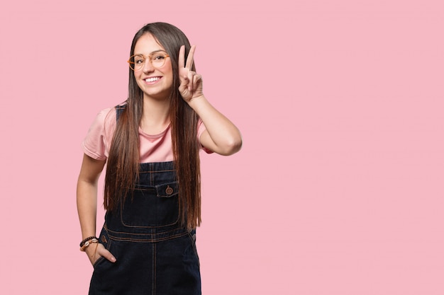 Joven mujer divertida y feliz haciendo un gesto de victoria