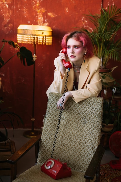 Foto joven mujer elegante de moda posando con teléfono retro maquillaje brillante y cabello de color