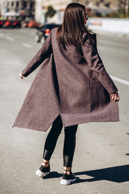 Joven mujer elegante posando en una calle de la ciudad