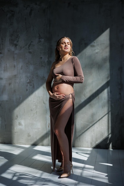 Joven mujer embarazada en top beige y falda Maternidad embarazo espacio de copia Moda para el embarazo Feliz período de embarazo
