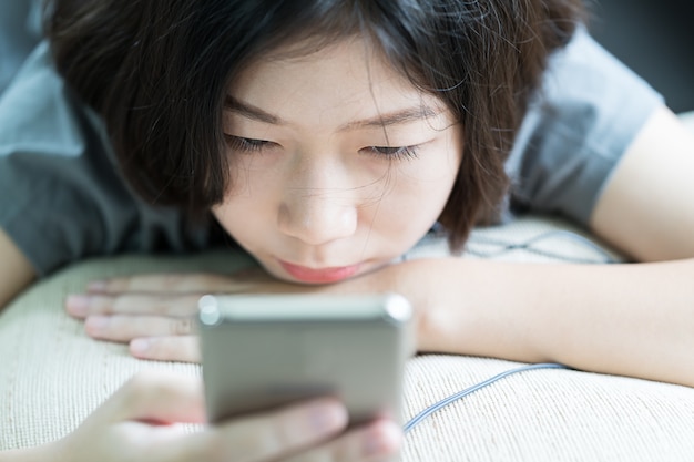 Joven mujer escuchando música desde el teléfono móvil