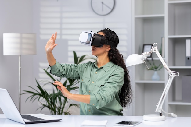 Joven mujer exitosa dentro de la oficina usando gráficos cruzados del simulador de realidad virtual de gafas vr y