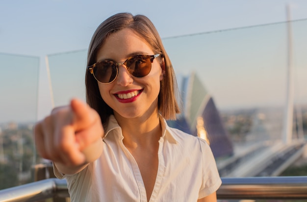 joven mujer feliz apuntando en una ciudad