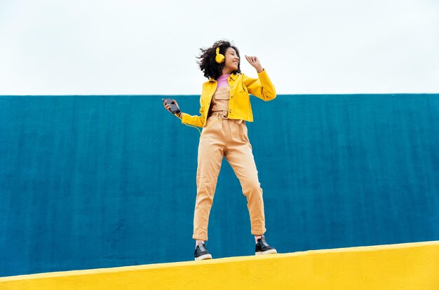 Joven mujer feliz bailando y divirtiéndose al aire libre