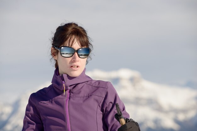 Joven mujer feliz con bastones de esquí en esquí de invierno