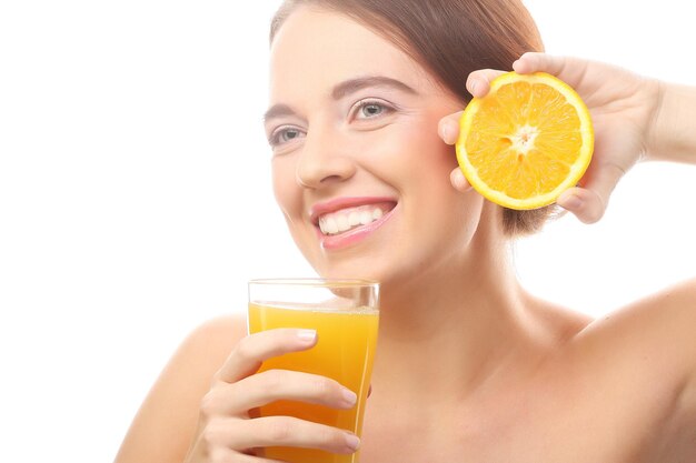 Joven mujer feliz bebiendo jugo de naranja