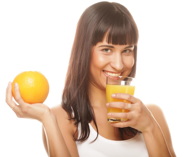 Joven mujer feliz bebiendo jugo de naranja