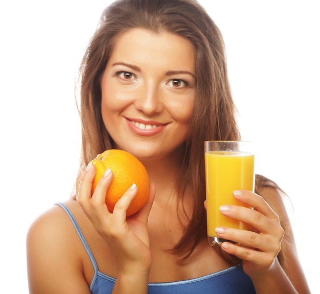 Joven mujer feliz bebiendo jugo de naranja