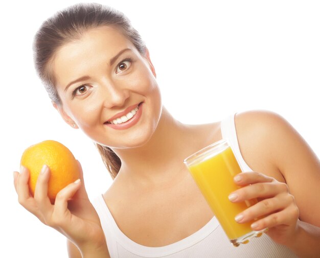 Joven mujer feliz bebiendo jugo de naranja