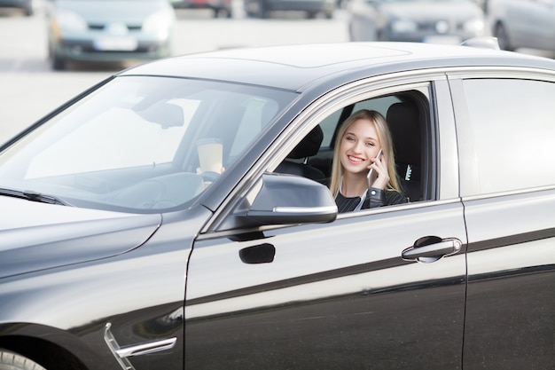 Joven mujer feliz compró nuevo coche moderno