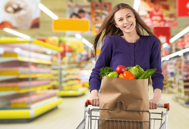 Joven, mujer feliz, empujar, carro de compras