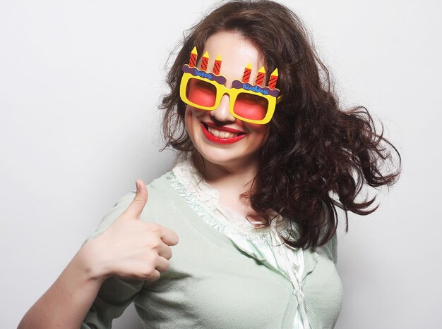 Joven mujer feliz con grandes gafas de sol naranjas, lista para la fiesta