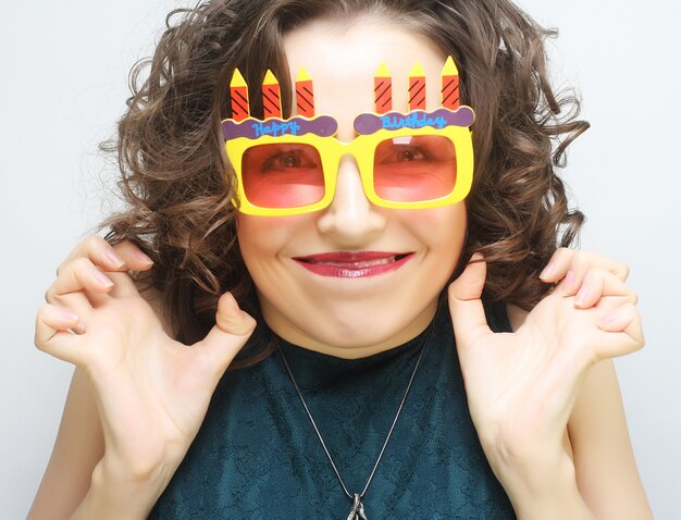 Joven mujer feliz con grandes gafas de sol naranjas