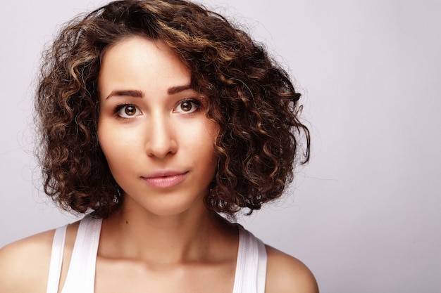 Joven mujer feliz con el pelo rizado