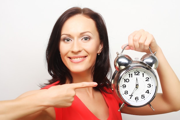 Joven mujer feliz con reloj despertador