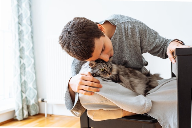 Joven mujer feliz se sienta en un sillón en la sala de estar mascotas hermoso gato