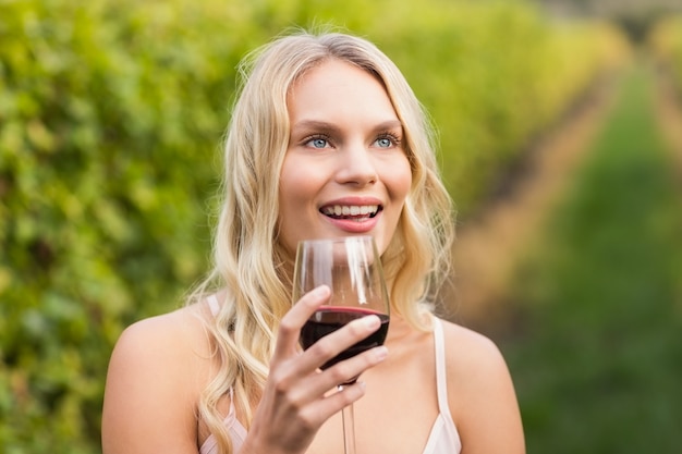 Joven mujer feliz sosteniendo un vaso de vino