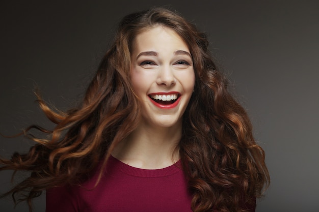 Joven mujer feliz con viento en el cabello