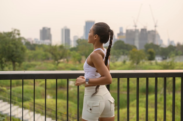 Una joven mujer fitness en ropa deportiva haciendo ejercicio en el parque de la ciudad Saludable y estilos de vida